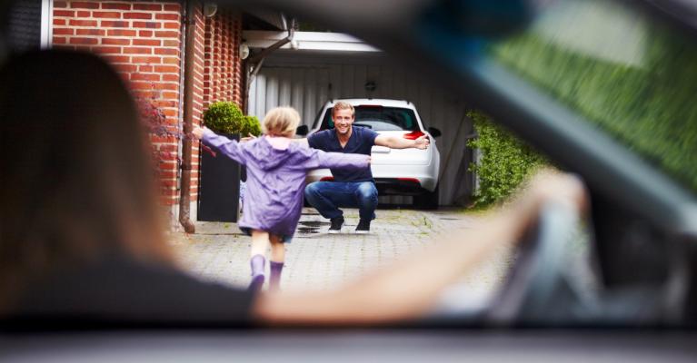 Mor sitter i bilen og ser datteren løpe mot far som venter med åpne armer