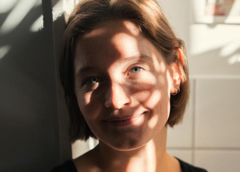 Ung kvinne med sol og skygge på ansiktet