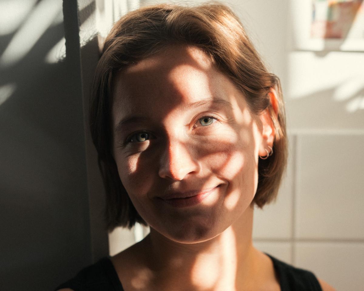 Ansikt av kvinne med halvlangt hår i sollys og skygge