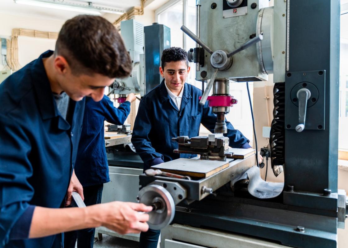 To lærlinger-gutter får undervisning på verksted